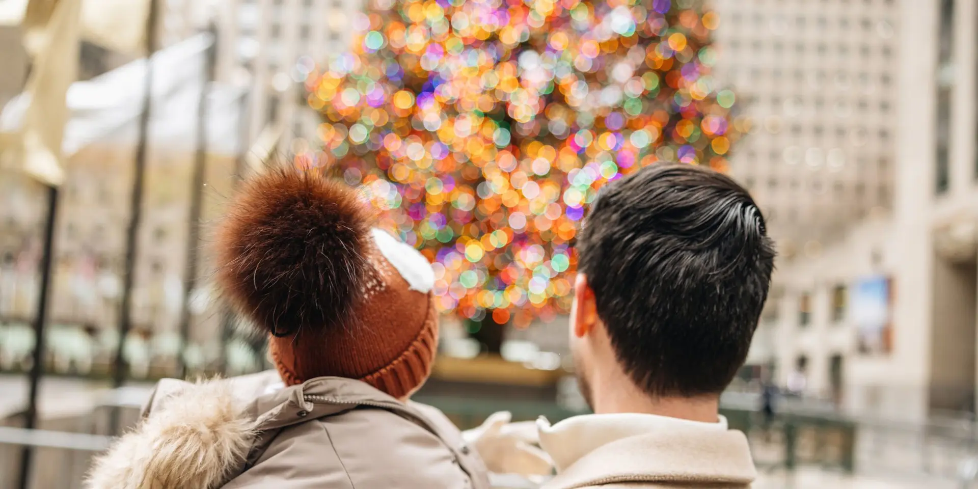 a father and son looking at the rockefeller center christmas tree