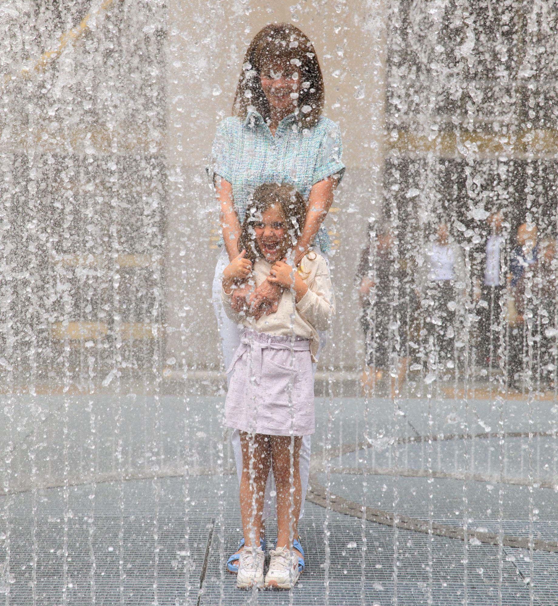 Mother and daughter interacting with artist Jeppe Hein's "Changing Spaces" installation at Rockefeller Center