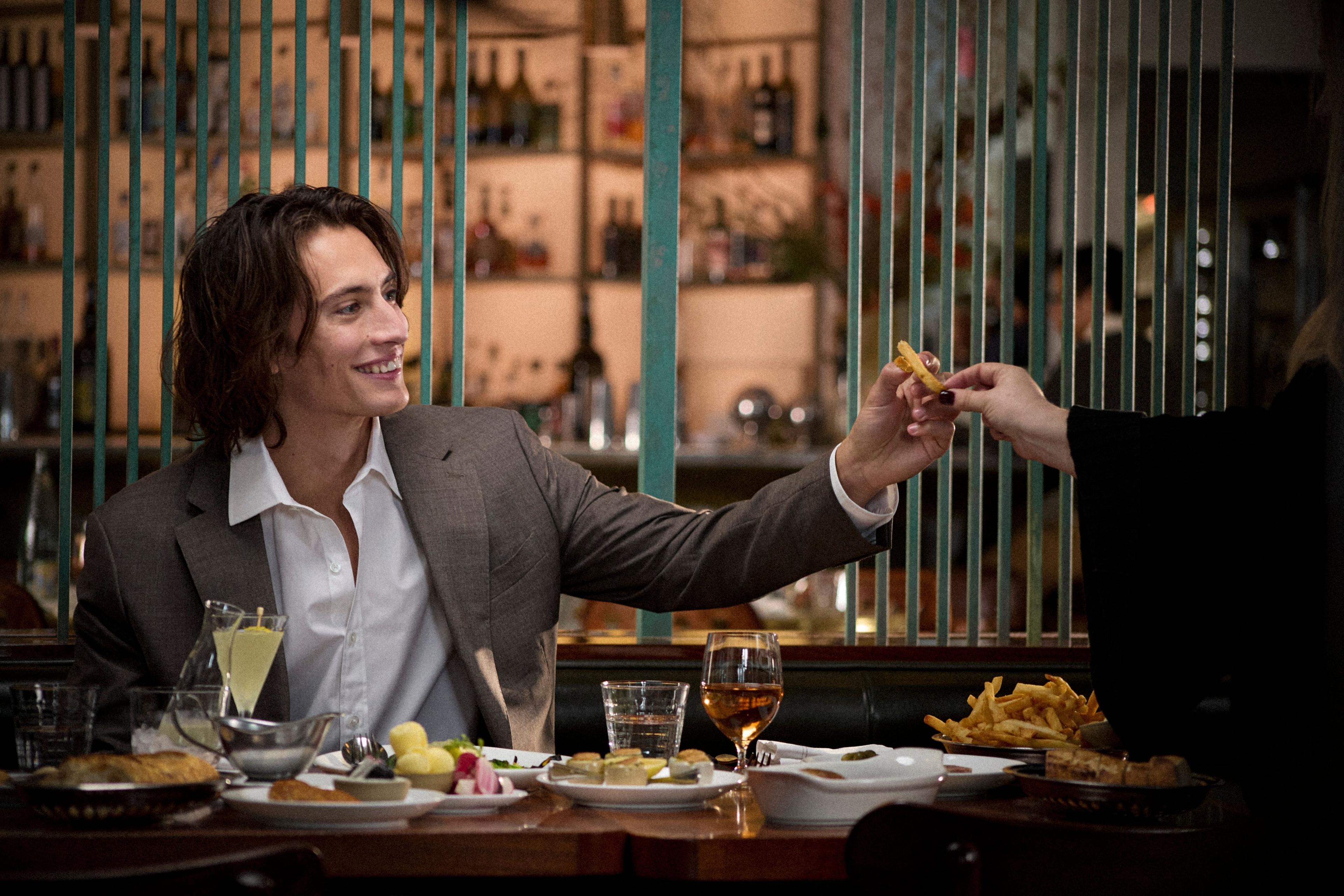 A diner being offered a french fry