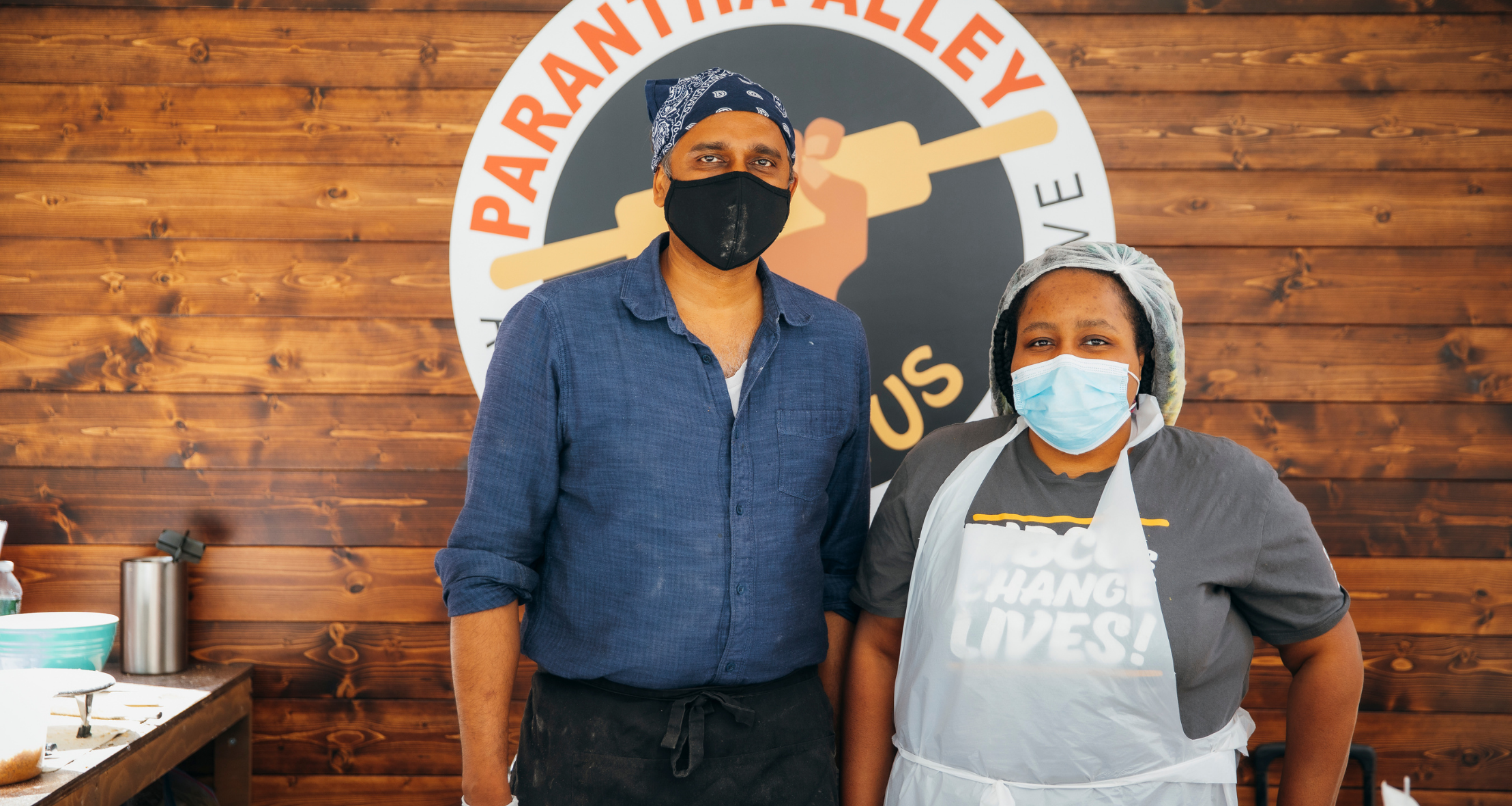 Two employee's standing in the Parantha Alley stand at the Queens Night Market Outpost at Rockefeller Center