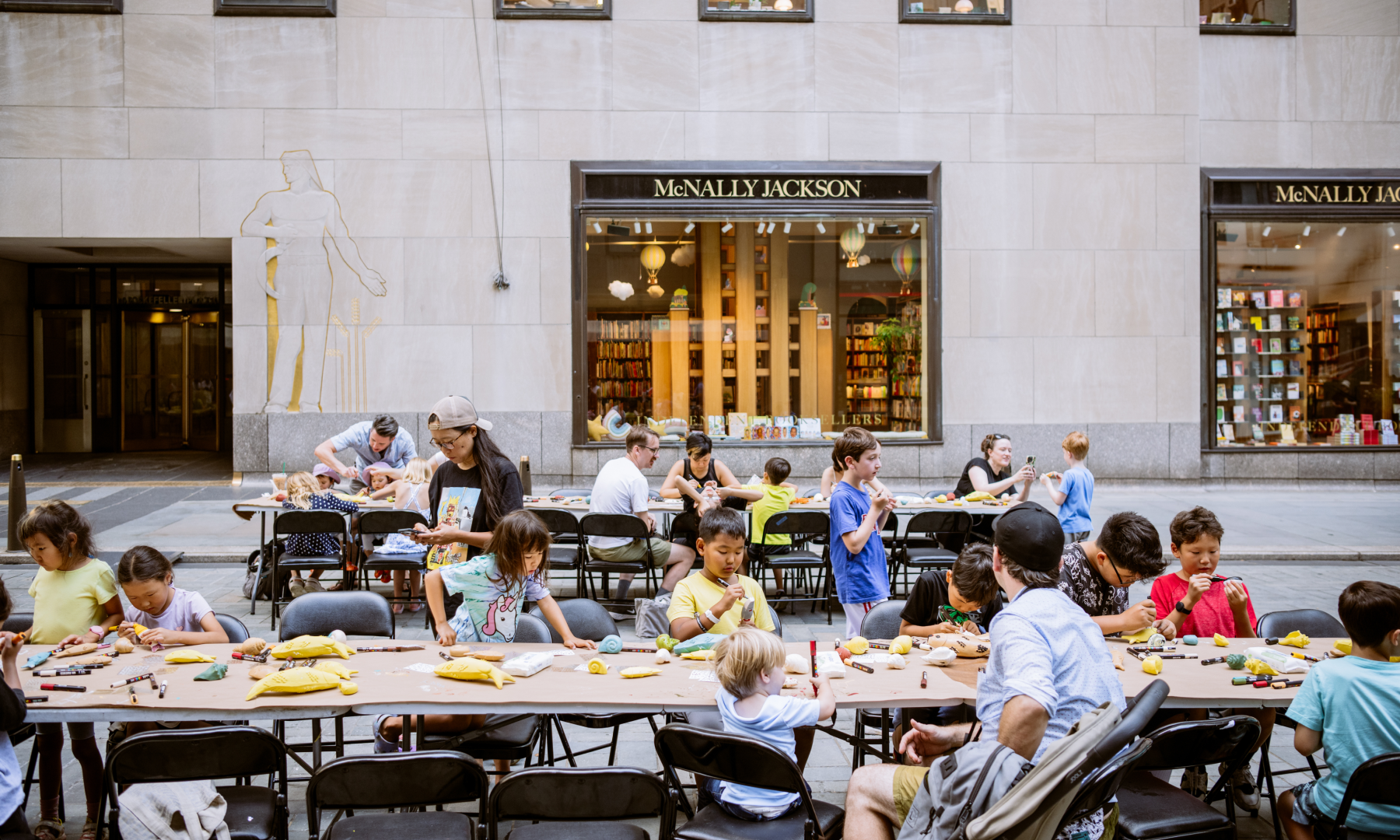A group of parents and children participating in an artist-led Art in Focus workshop at Rockefeller Center