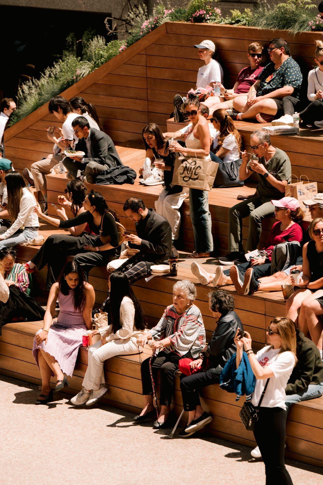 people sitting on wooden stairs in the sun