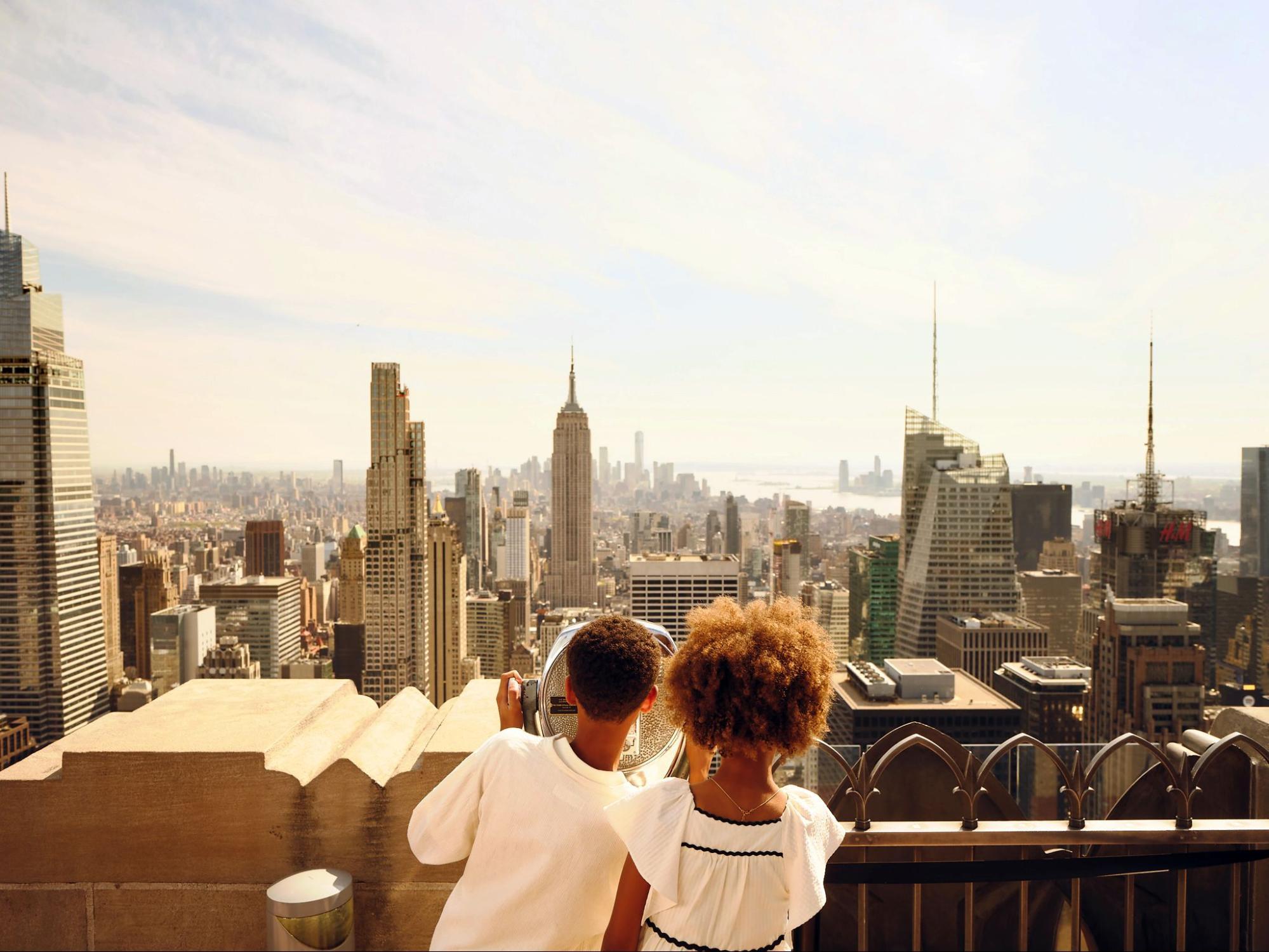 Kids overlooking NYC skyline from Rockefeller Center