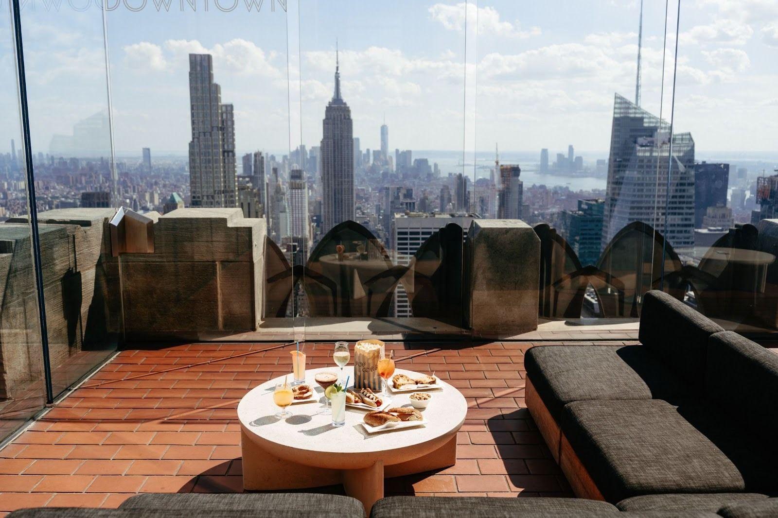 table of food on the Top of the Rock deck with the city skyline in the background