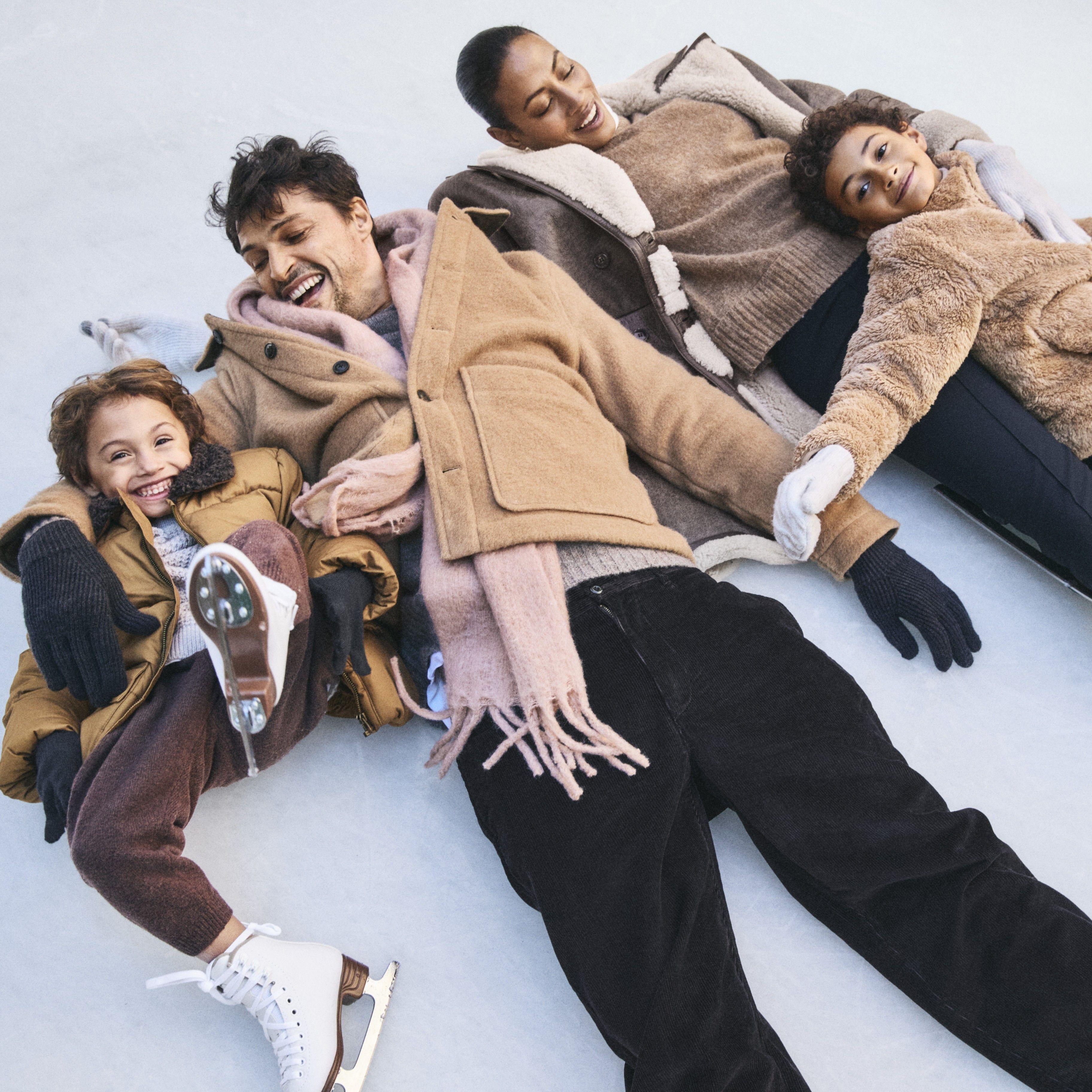 family in ice skates smiling on the ice